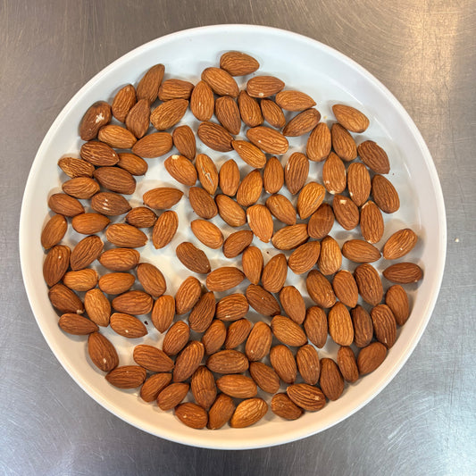 Fresh OKA-OKA roasted almonds in a white bowl, perfect for healthy snacking or cooking add-ons