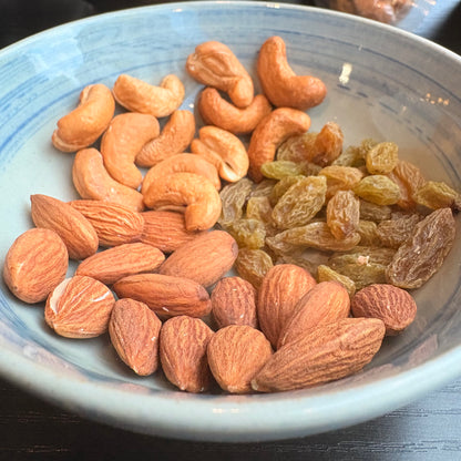 OKA-OKA Mixed Nuts including Almonds, Cashews, and Raisins in a Blue Bowl for Healthy Snacking