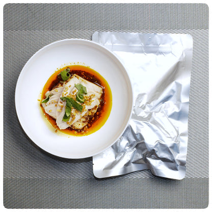 Sichuan-style mouthwatering chicken served in a bowl with flavorful sauce and garnished herbs